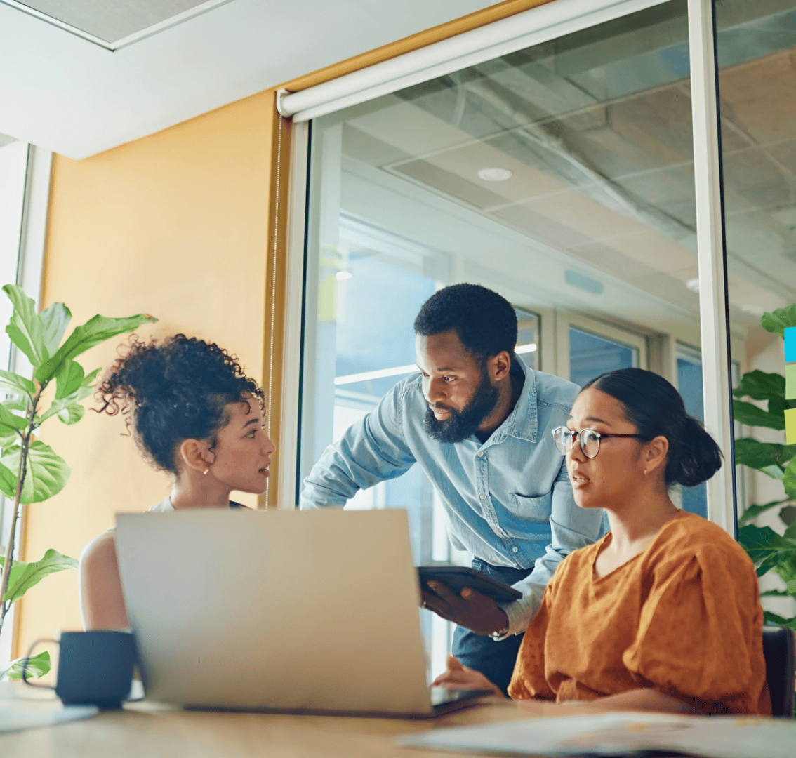 Three colleagues discussing work in office.